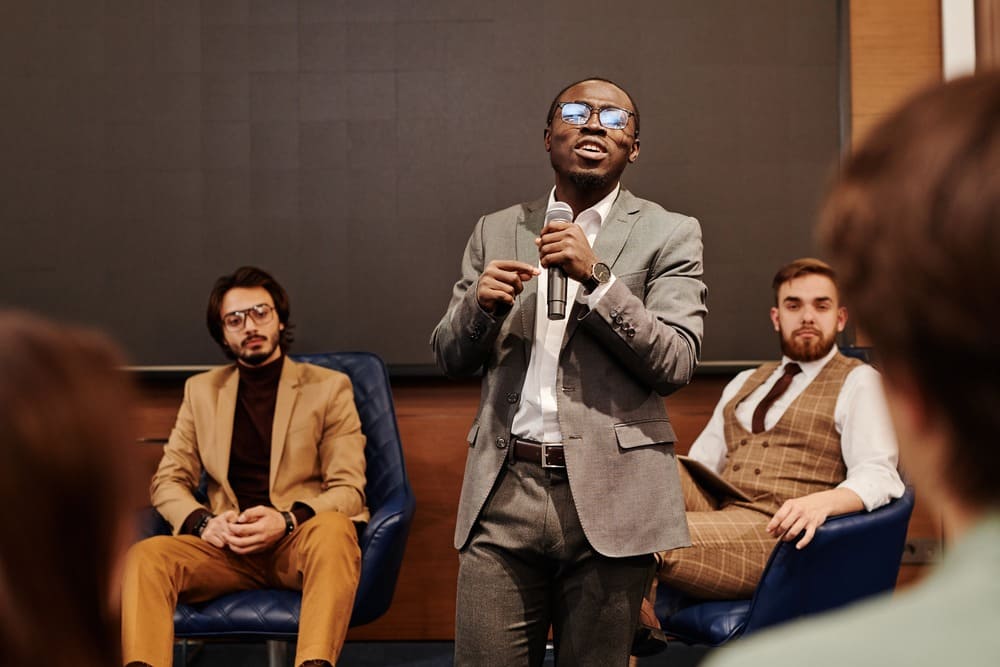 homem com um microfone apresentando evento corporativo